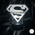 Bijela 3D LED lampa u obliku logotipa Superman. Na lampi je ugraviran tekst "SUPERTATA FILIP". Lampa se nalazi na tamnoj pozadini i u kutu je logotip "Giftmanija"