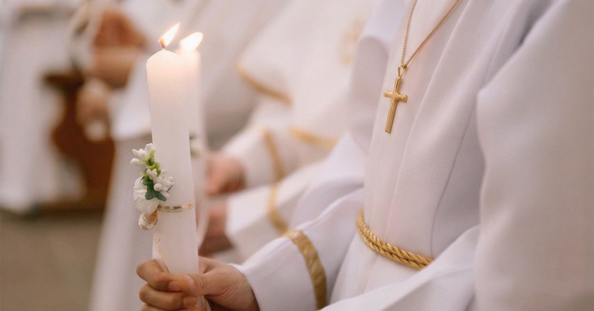 Prva sveta pričest slavlje - dijete drži ukrašenu svijeću i nosi zlatni križić oko vrata.