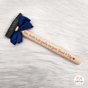 Personalizirani čekić za tatu s plavom mašnom, ugraviranom porukom "Tata hvala ti što gradiš naš život" i imenima djece te imenom na metalnoj glavi.