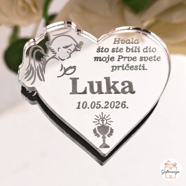 Srebrni akrilni magnet u obliku srca s gravurom anđela i tekstom zahvale za prvu svetu pričest.