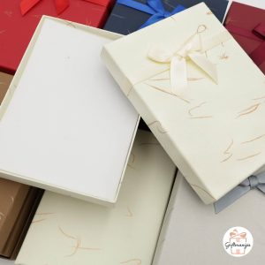 Elegantne ukrasne kutije za nakit i sitnice; u prvom planu je otvorena krem kutija s mašnom.